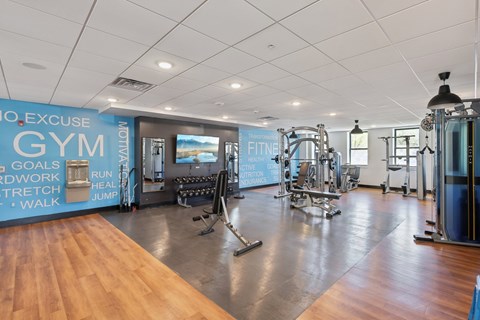 A gym with a variety of equipment and a sign that reads "No Excuse Gym".