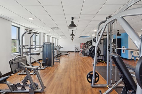 A gym with a variety of equipment including weights and machines.