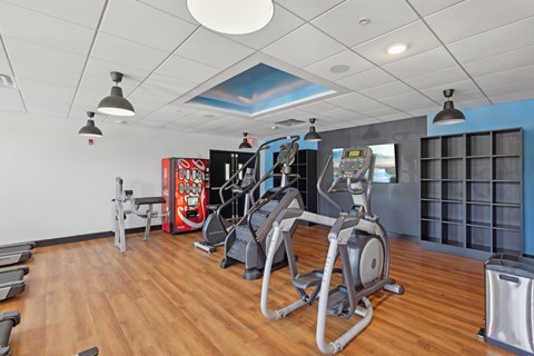 A gym with a variety of equipment including treadmills, stationary bikes, and weight machines.