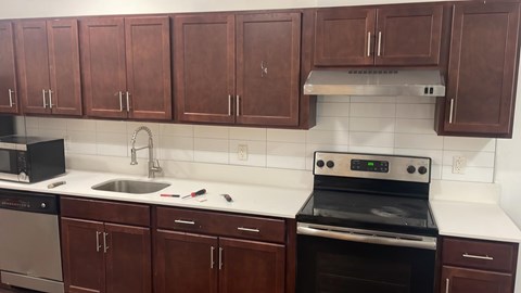 A kitchen with brown cabinets and a black oven.