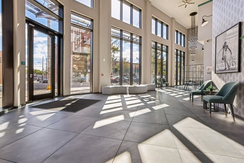 A sunny day at the lobby of a building with a bicycle hanging on the wall.
