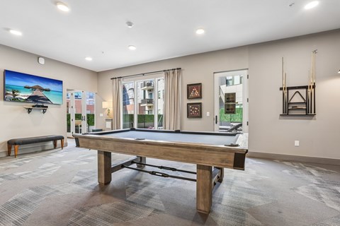 A room with a pool table and a bench.