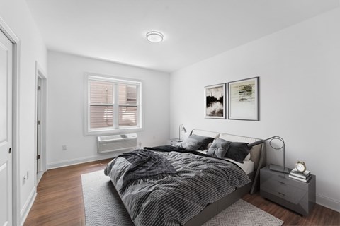 A bedroom with a bed, nightstand, and pictures on the wall.