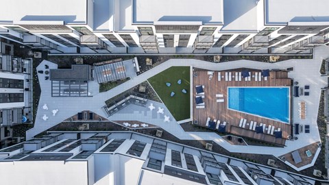 A top-down view of a building with a pool and a green area.