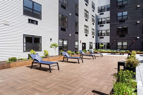 A patio with a bench and a building in the background at Art Of Newark, Newark, NJ