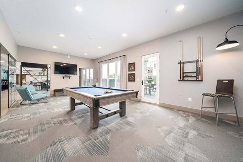A room with a pool table and a chair.