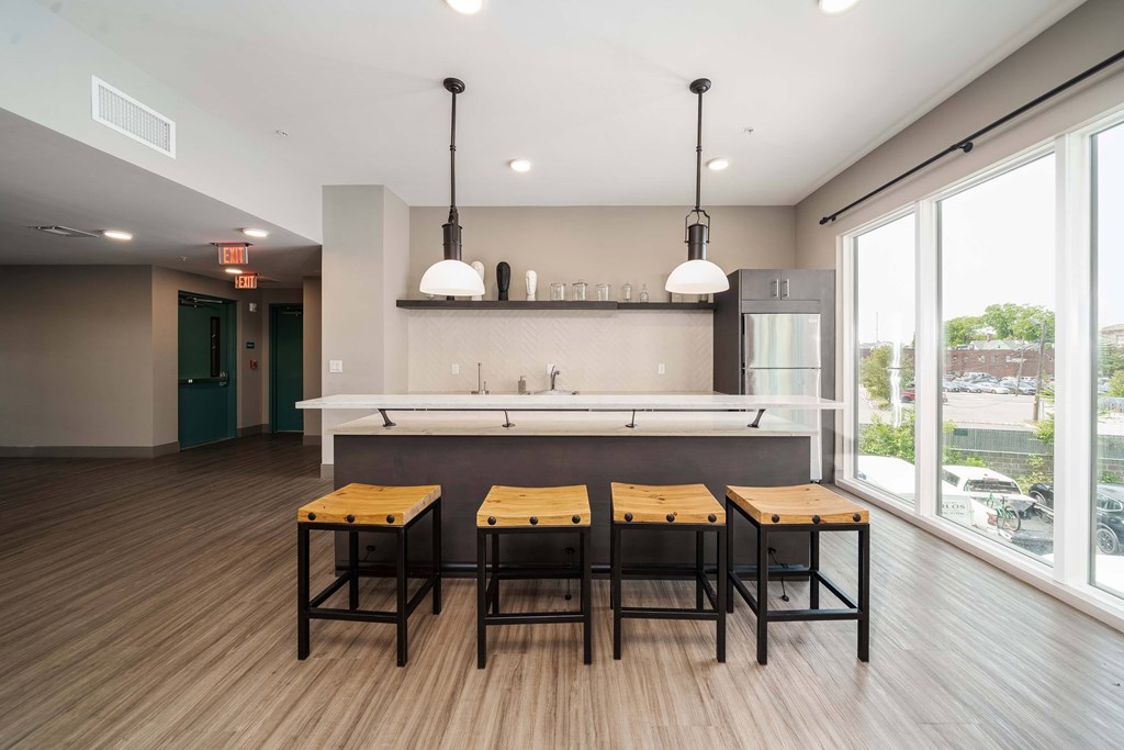 A modern kitchen with a bar area and three stools at Crossroads 389 Apartments, Hackensack