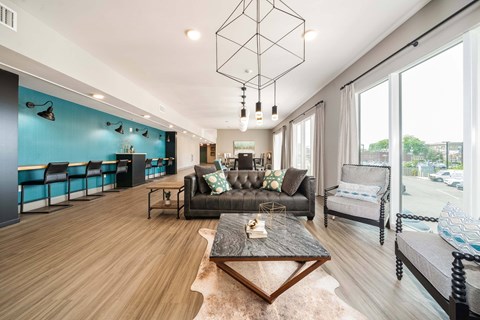 A modern living room with a black leather couch and a wooden coffee table.