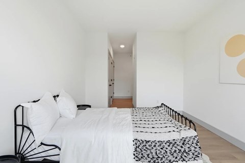 A bed with a white comforter and a black metal frame.