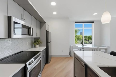 A modern kitchen with a black stove top oven and a black microwave.