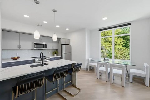 A modern kitchen with a large island and a dining area.