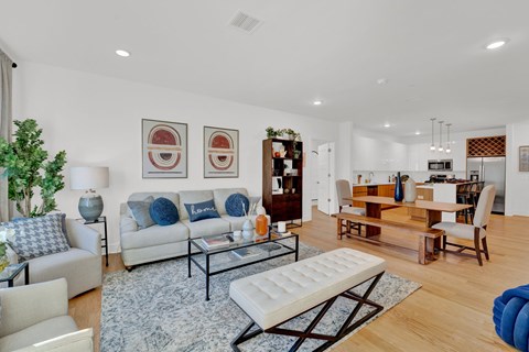 A living room with a white couch and a blue ottoman.