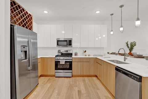 A modern kitchen with wooden cabinets and stainless steel appliances.