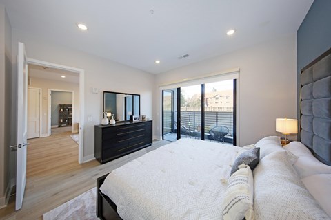 A bedroom with a large bed and a dresser.