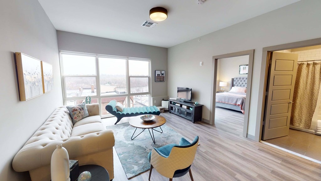A living room with a white sofa and a blue chair at Crossroads 389 Apartments, New Jersey, 07601