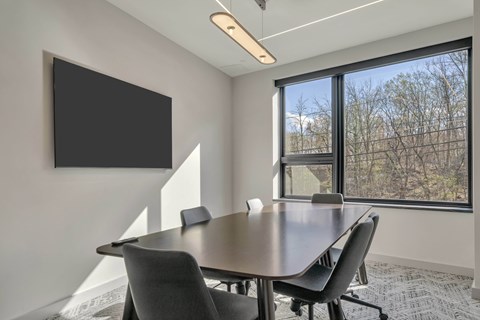 A conference room with a large table and chairs.