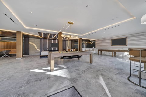 A modern dining room with a long table and chairs.
