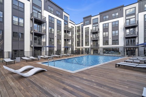 A large apartment complex with a pool in the middle.