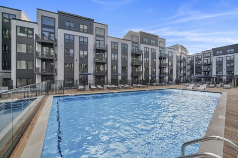 A large swimming pool in front of apartment buildings.