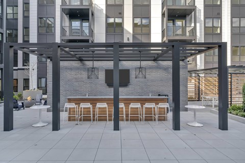 A patio with a table and chairs under a pergola.