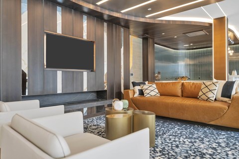 A modern living room with a large television and comfortable seating.