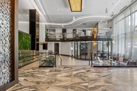 A modern lobby with a glass wall and a marble floor.