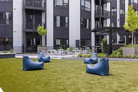 A grassy area with two bean bag chairs in front of a building.