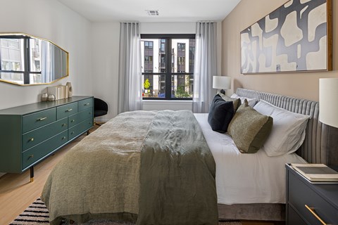 A bedroom with a large bed and a large window.