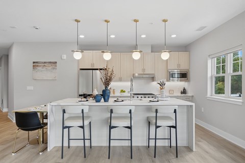 A modern kitchen with a waterfall island and stainless appliances