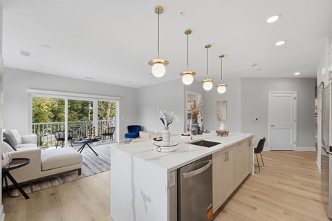 A modern kitchen with a large island and pendant lights.