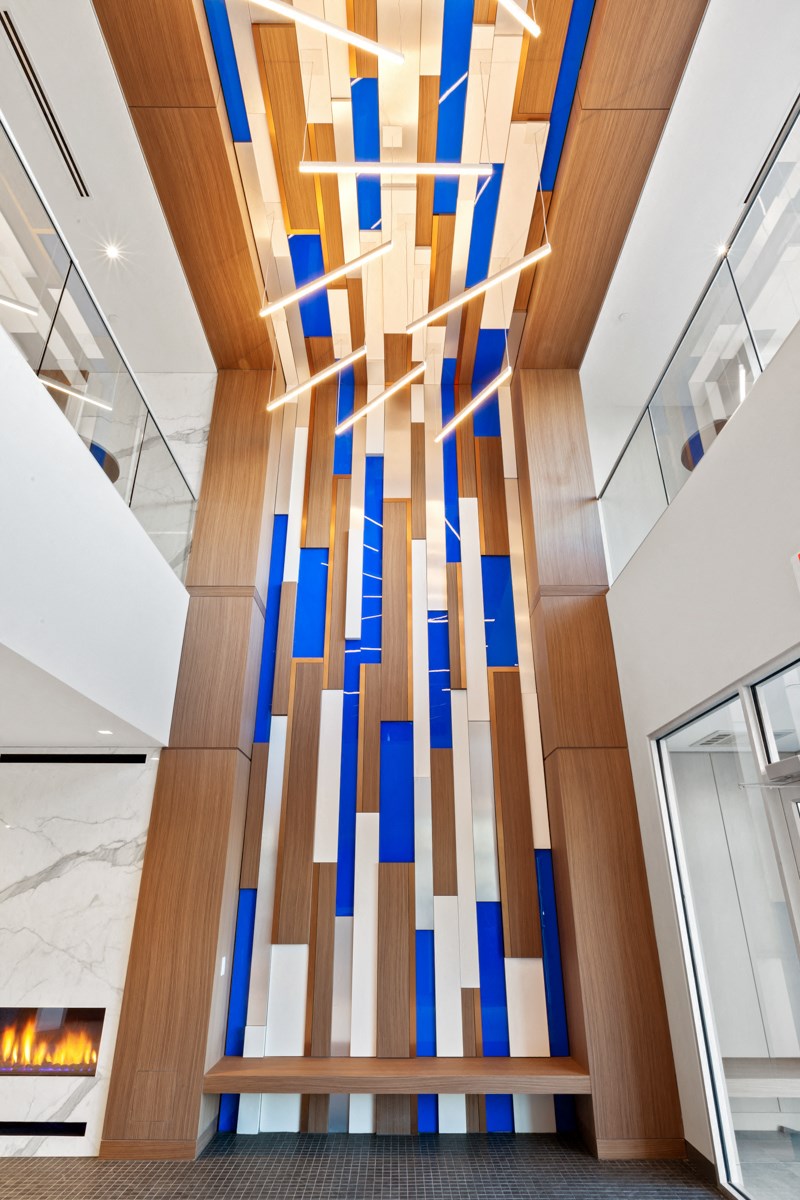 the lobby of a building with a large glass art installation on the wall