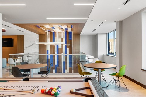 a room with a pool table and a table with chairs