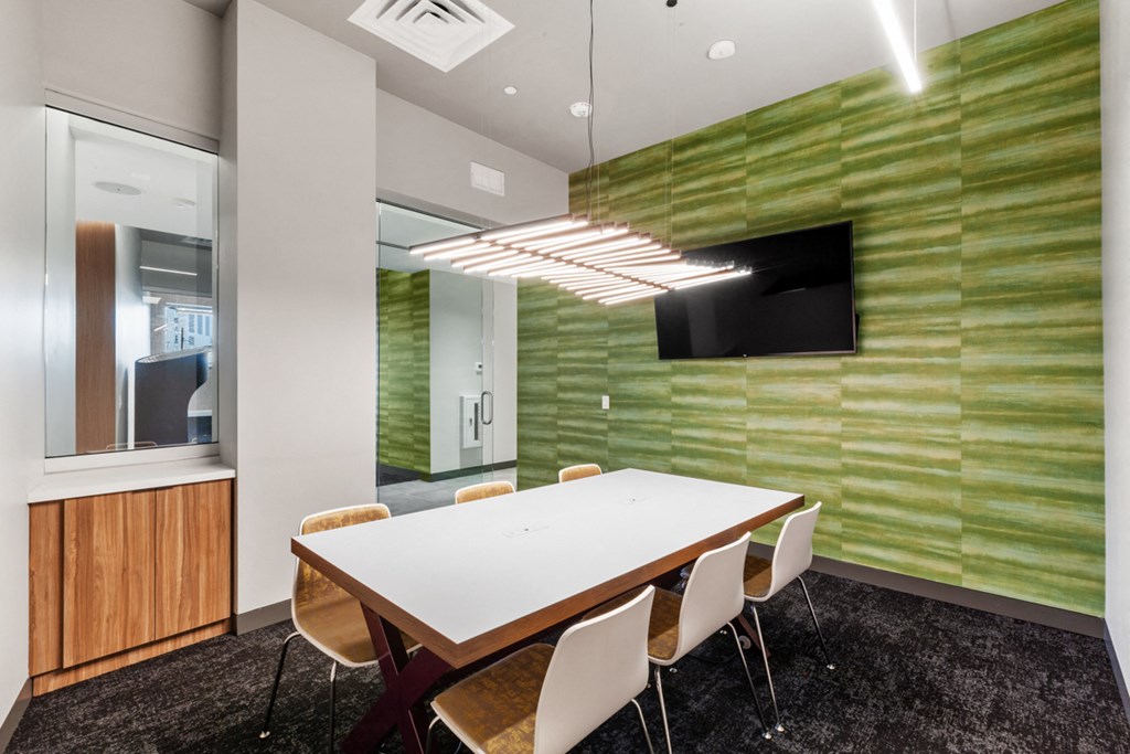 a conference room with a white table and chairs and a television