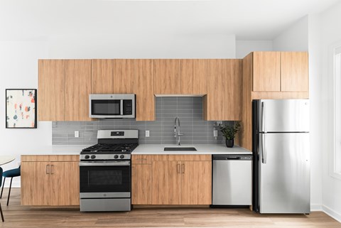 A modern kitchen with wooden cabinets and stainless steel appliances.
