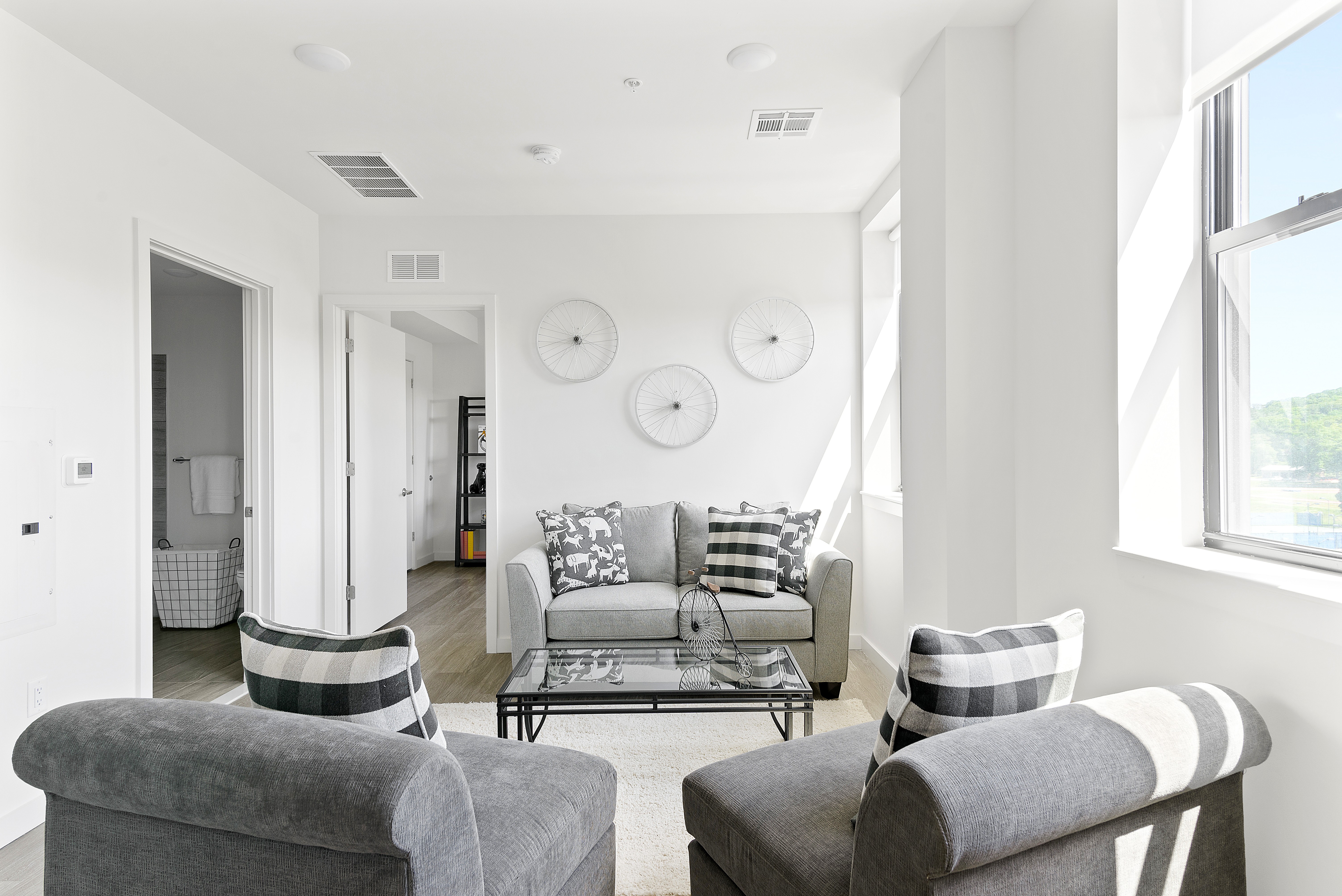 A living room with a grey couch and two grey armchairs.