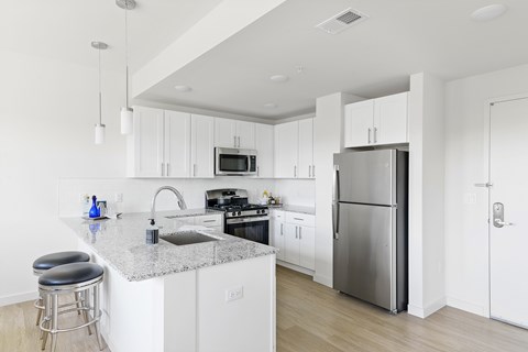 A modern kitchen with white cabinets and stainless steel appliances.
