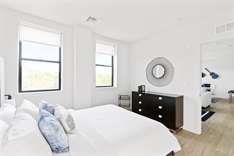 A white bedroom with a large bed and a window.