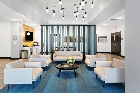 A modern waiting room with a long couch and a coffee table.