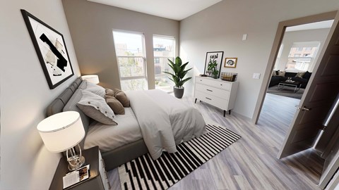 A bedroom with a bed, nightstand, and a plant.