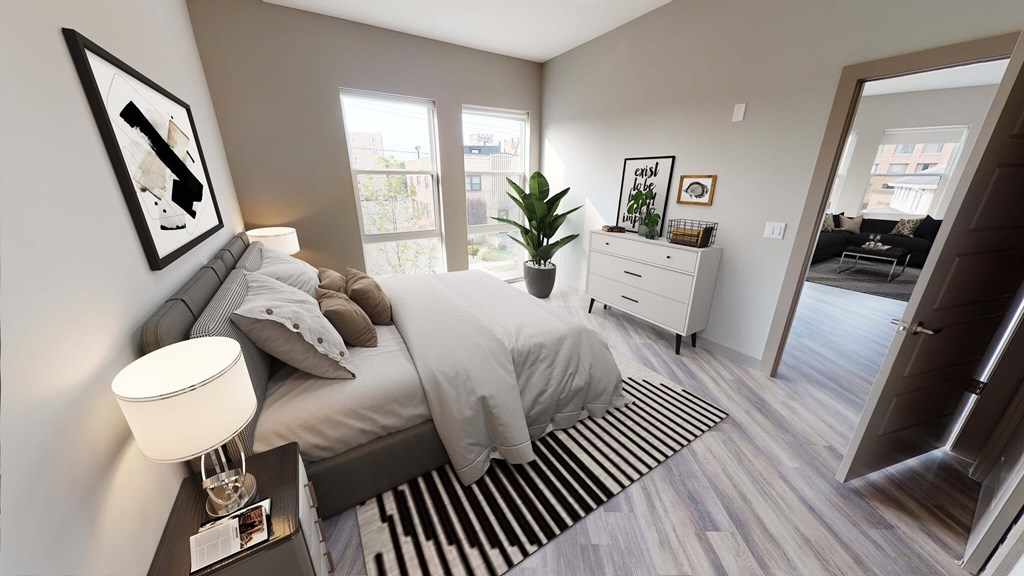 A bedroom with a bed, nightstand, and a plant. A bedroom with a bed, nightstand, and a plant at Crossroads 389 Apartments, Hackensack, NJ