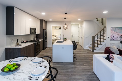 A modern kitchen with a dining table set for two.