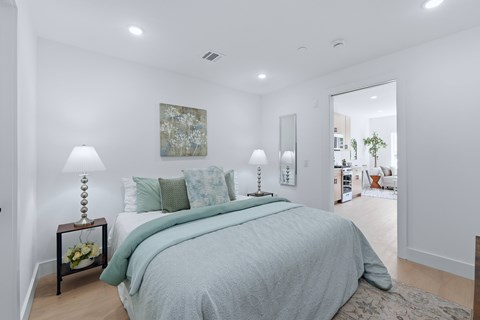 A bedroom with a large bed and a painting on the wall.