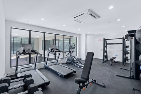 A spacious gym with treadmills, weights, and exercise equipment.