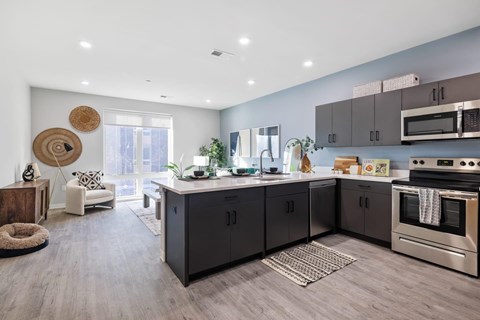 A modern kitchen with dark wood cabinets and stainless steel appliances.