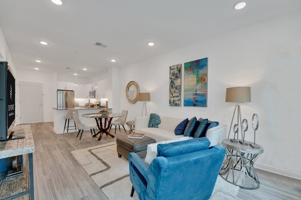 an open living room with a couch and a chair and a dining room table