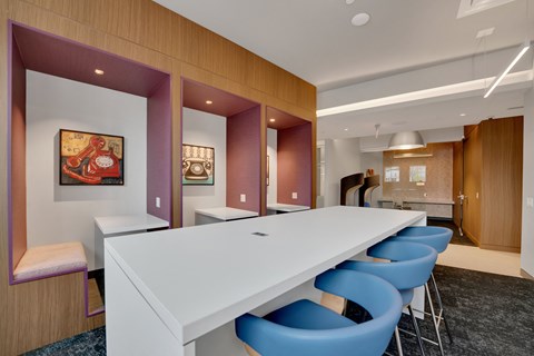 a long white table in a room with blue chairs