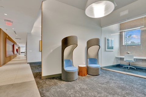 a communal area with two chairs and a sink in a room