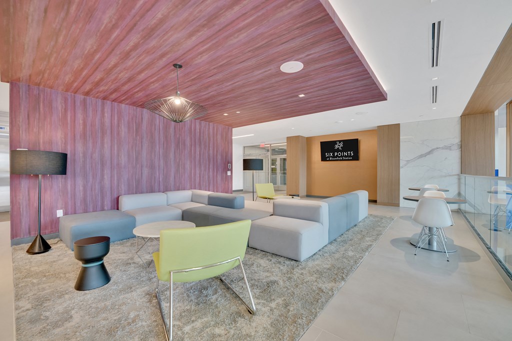 a living room with couches and chairs and a wooden wall