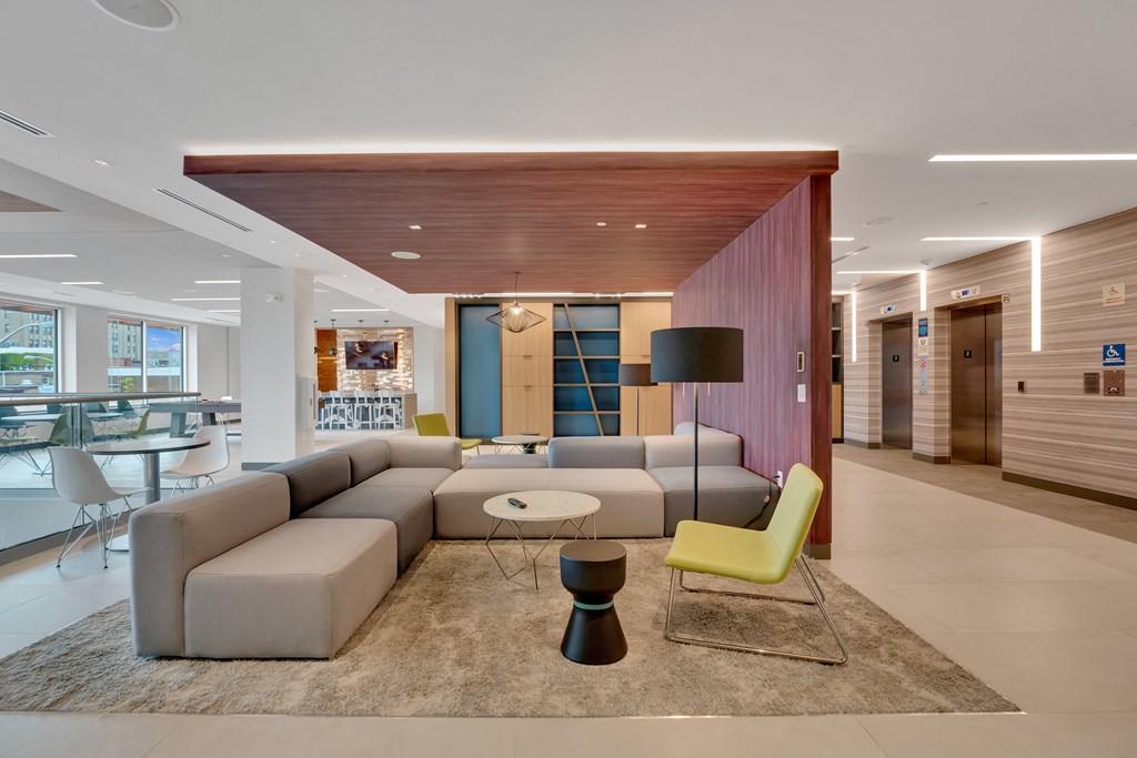 a living room with a gray couch and a yellow chair