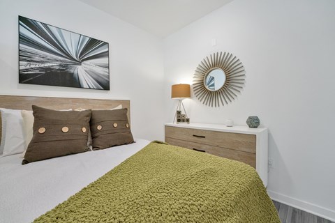 a bedroom with a bed with a green blanket